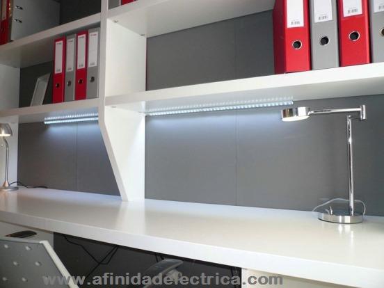 Iluminacion de un escritorio com tiras de LEDs de color blanco fr�o adheridas debajo de un estante. 